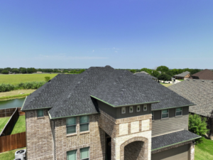 a large brick house with a green field and trees in the background
